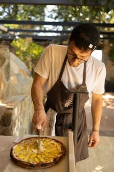 smiling male pizza chef in kitchen